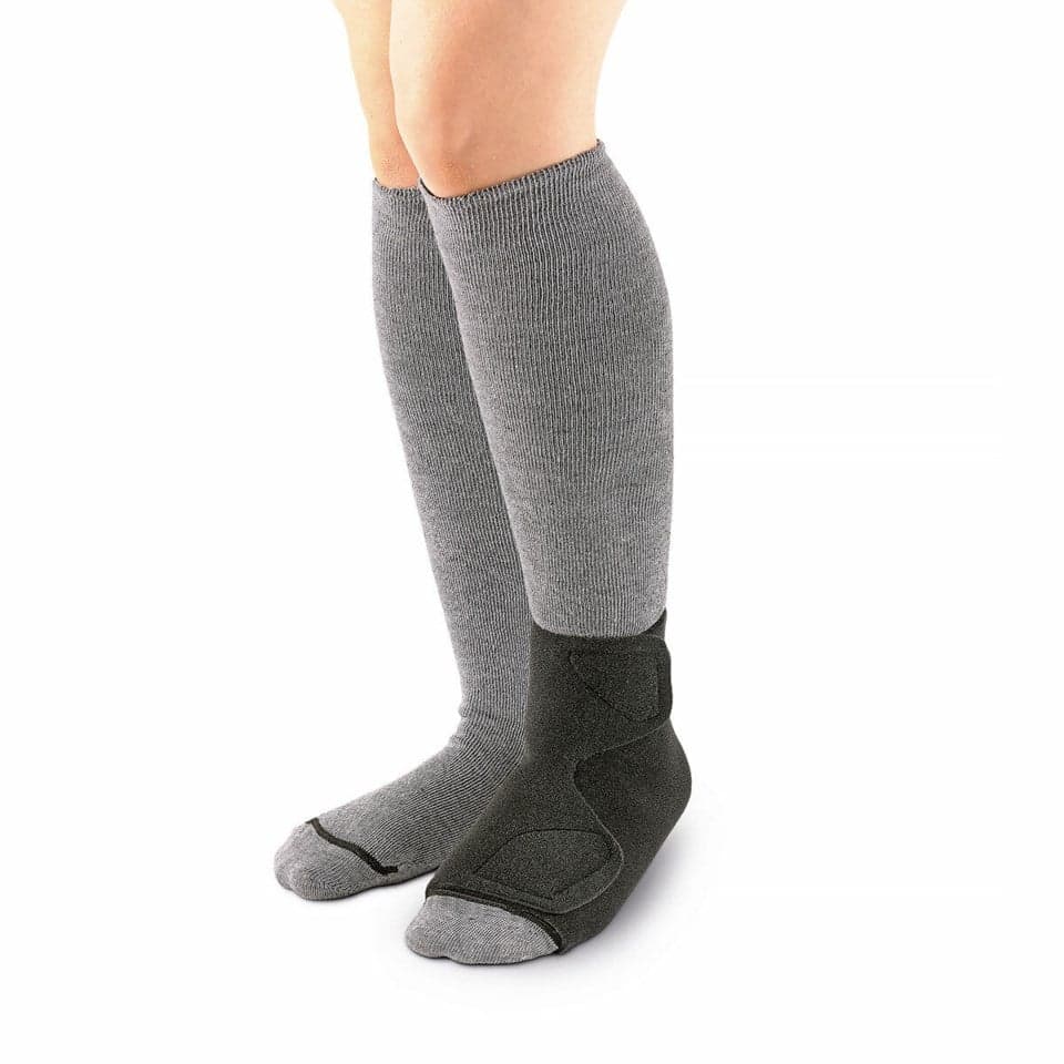 Sigvaris Compreboot Standard preto vestido no pé e tornozelo, com fechos de velcro, sobre fundo claro