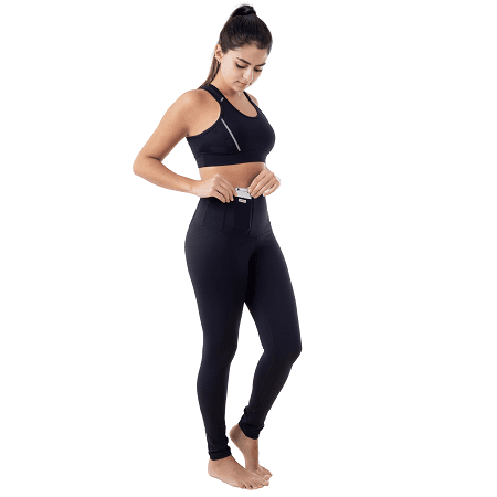 Modelo de corpo inteiro vestindo a legging Bioativa preta de cintura alta com top esportivo, ajustando o cós